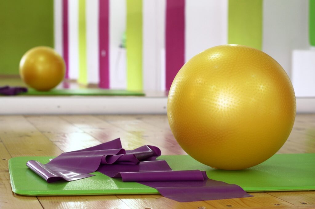 workout ball and yoga mat on a gym floor, two great pieces of exercise equipment to use to help reduce dementia risk